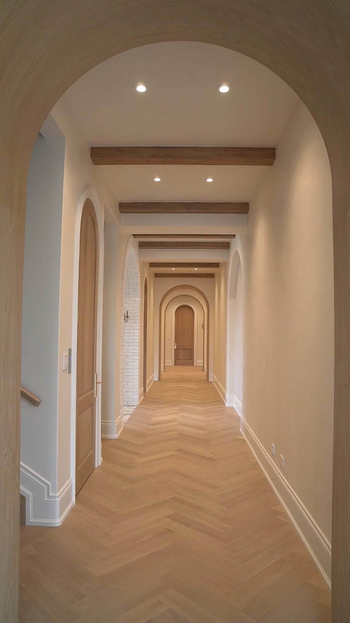 white-venetian-plaster-walls-kleinburg-house6 Custom Venetian plaster hallway with arched openings, oak details and herringbone flooring in a luxury Kleinburg home