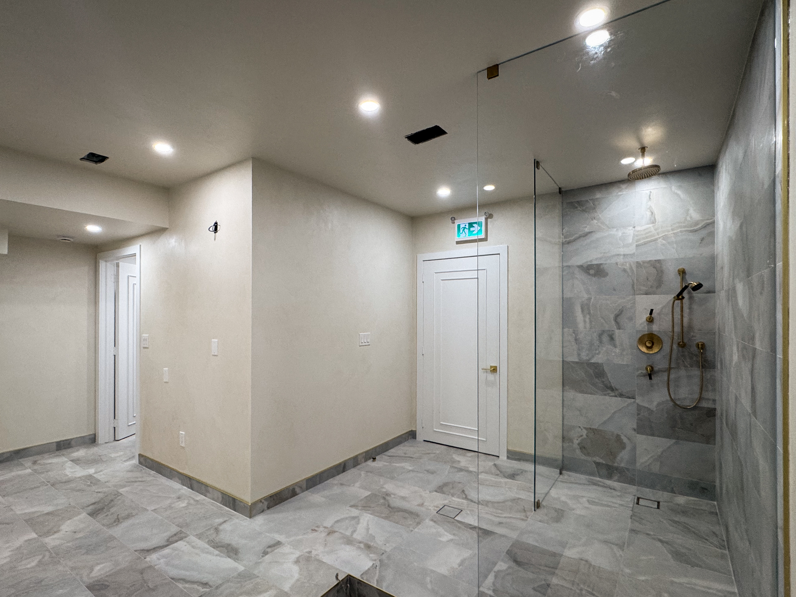 A view of a Mikvah pool in Mississauga, featuring walls and a ceiling finished in a seamless, soft off-white microcement with a subtle cloudy texture and hand-applied mineral variations.