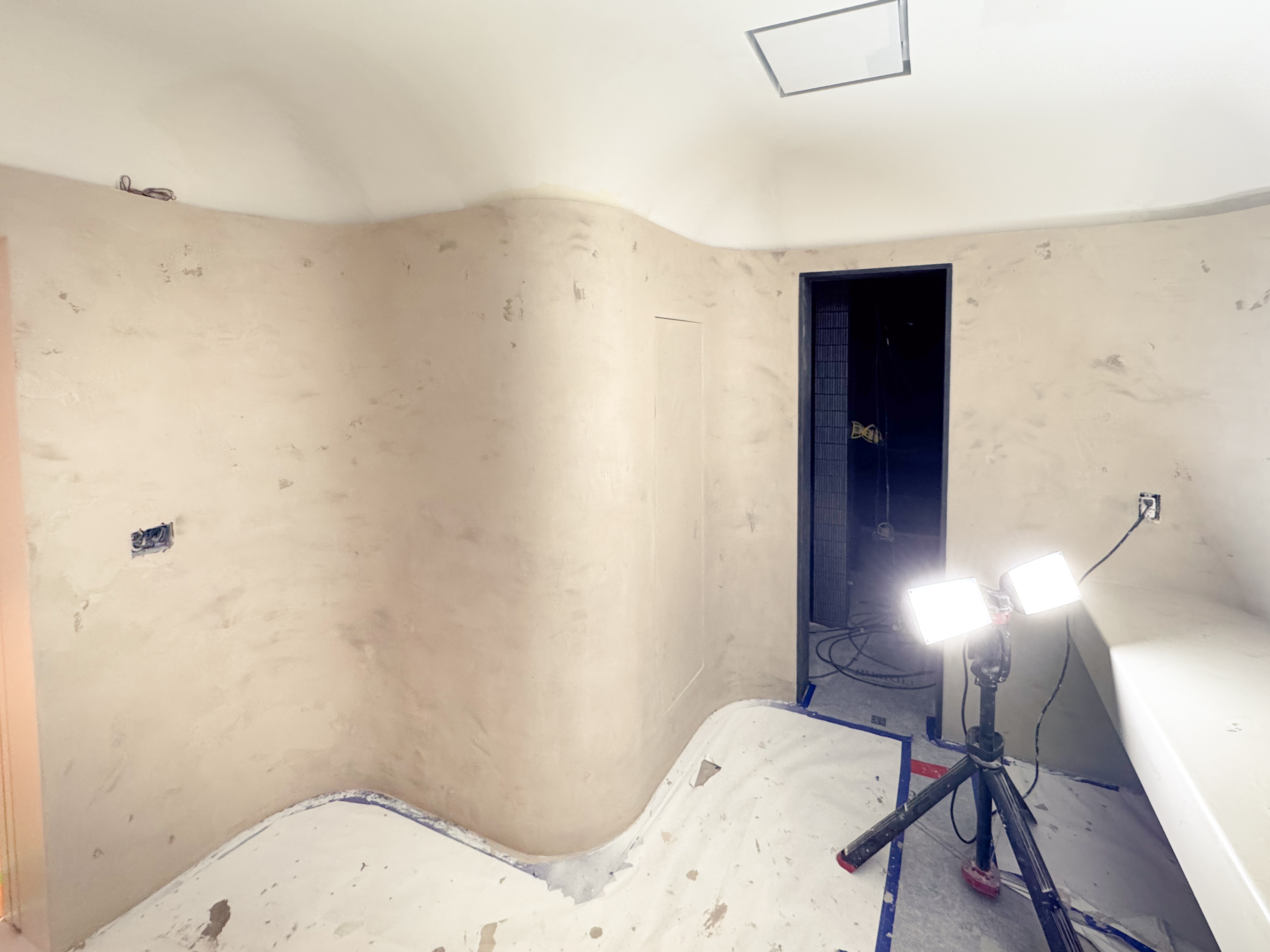 A contemporary home spa in Castle Frank, Toronto, featuring seamless soft grey microcement applied to the walls, closet doors, and a built-in vanity, finished with a matte, waterproof sealer.