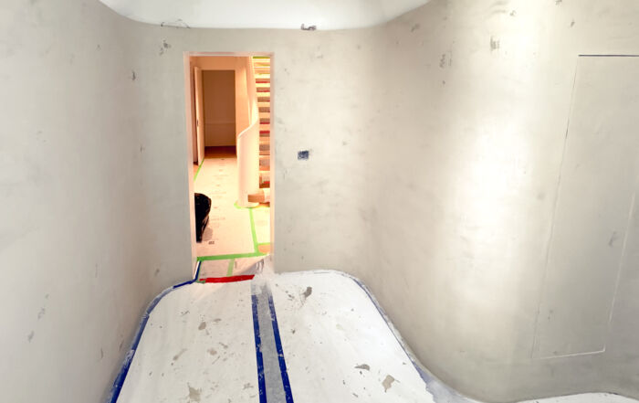 A contemporary home spa in Castle Frank, Toronto, featuring seamless soft grey microcement applied to the walls, closet doors, and a built-in vanity, finished with a matte, waterproof sealer.