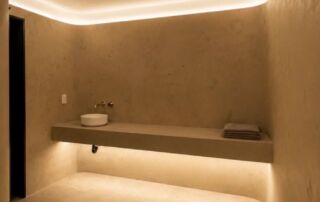 A contemporary home spa in Castle Frank, Toronto, featuring seamless soft grey microcement applied to the walls, closet doors, and a built-in vanity, finished with a matte, waterproof sealer.