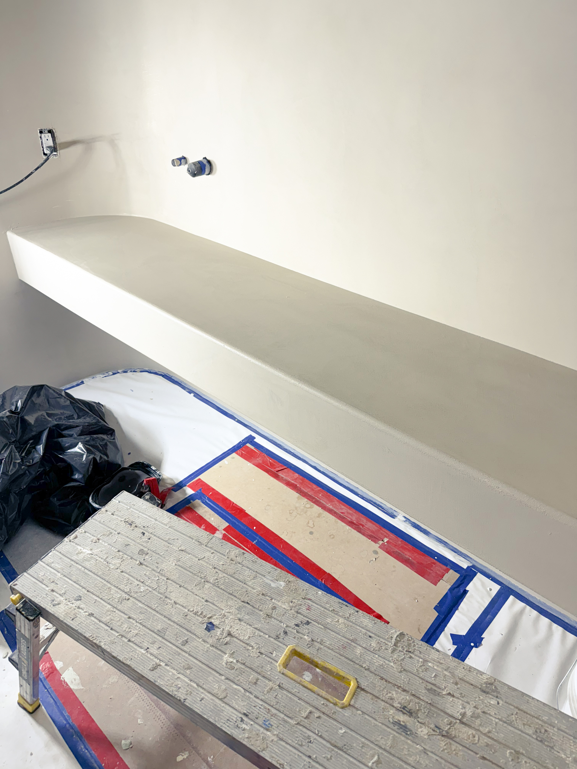 A contemporary home spa in Castle Frank, Toronto, featuring seamless soft grey microcement applied to the walls, closet doors, and a built-in vanity, finished with a matte, waterproof sealer.