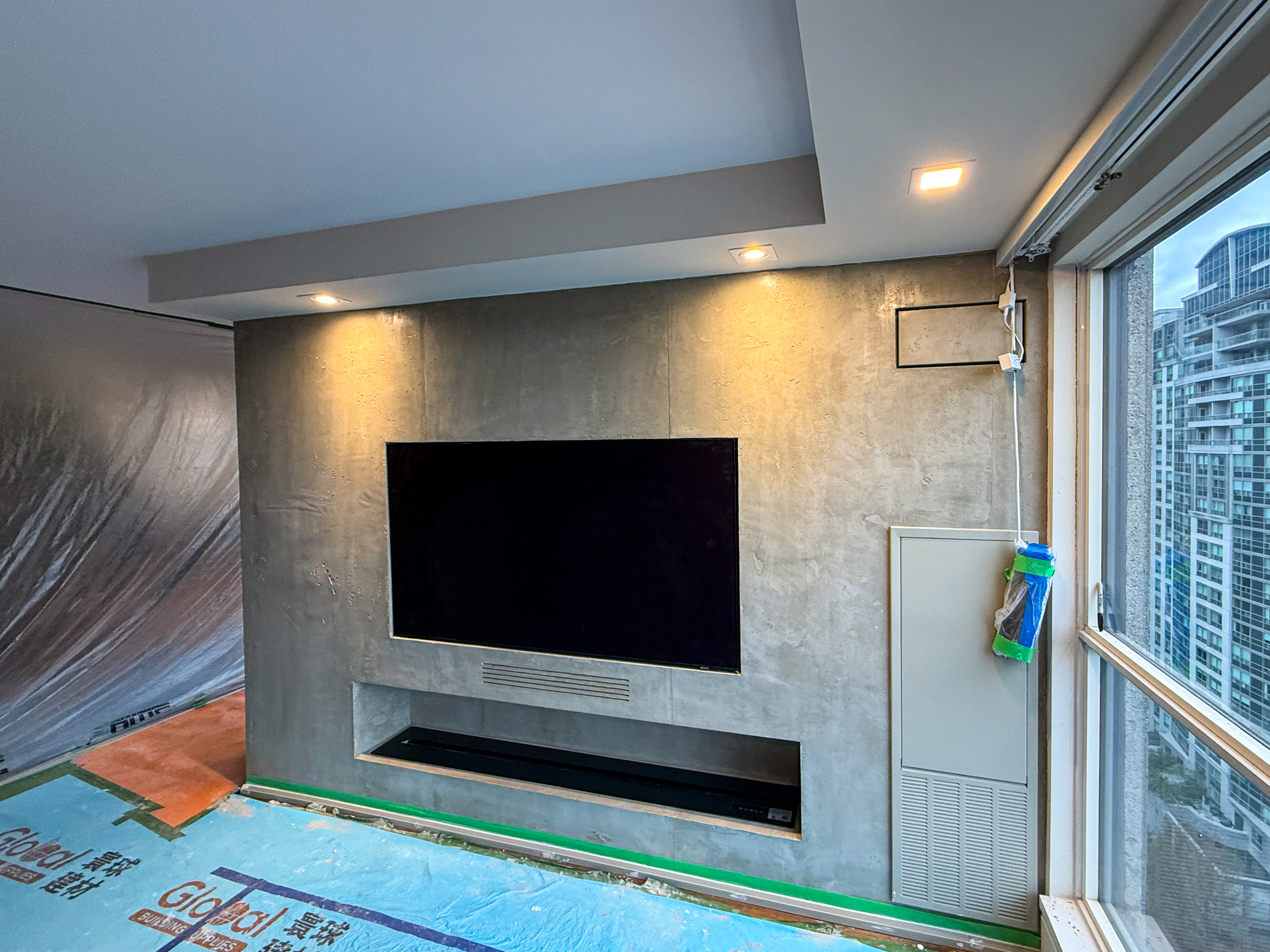 Artisan hand-troweling a concrete effect fireplace in a North York home.