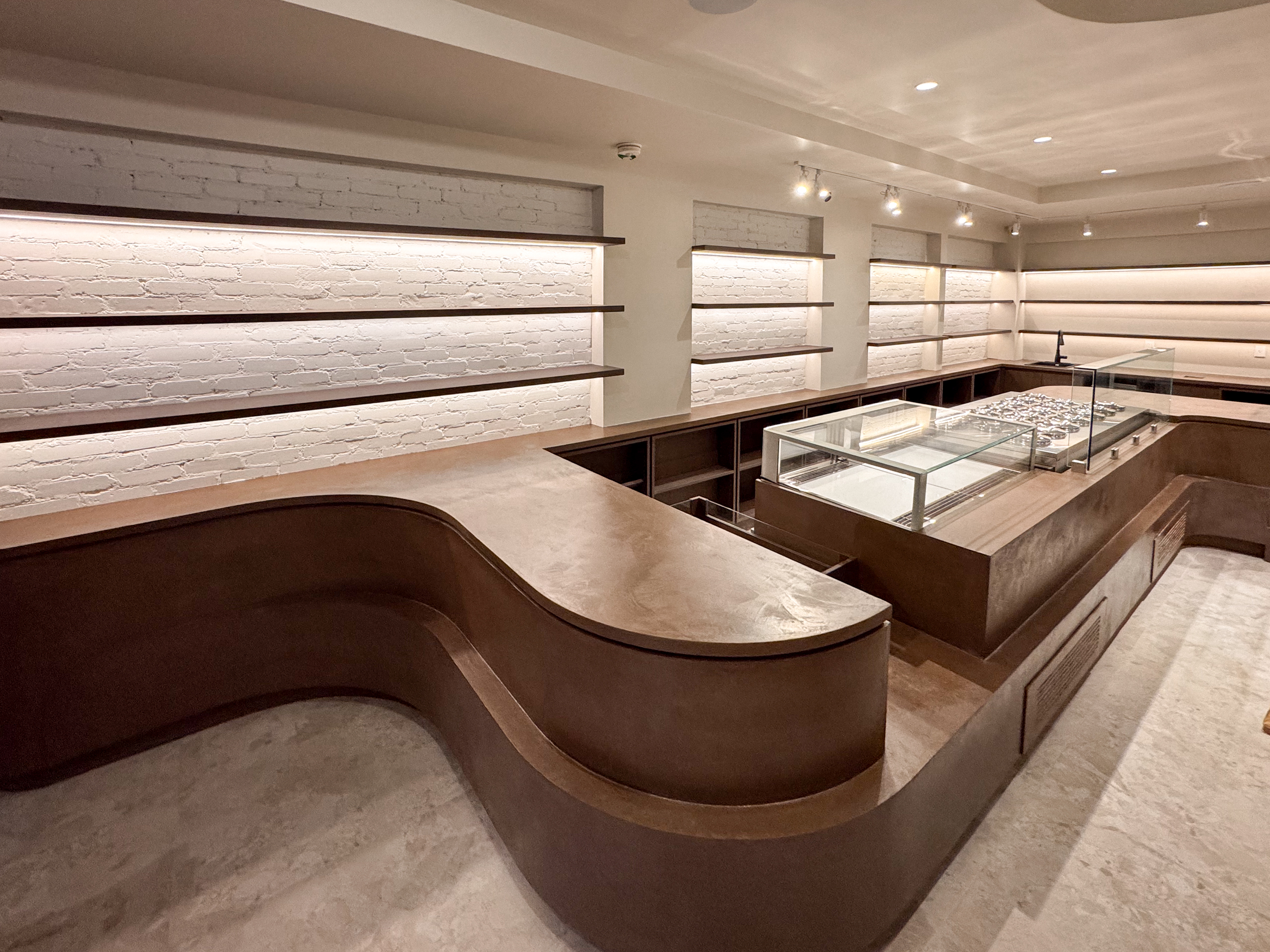 Finished deep coffee colored microcement commercial furniture counter in a Toronto gelateria after two coats.