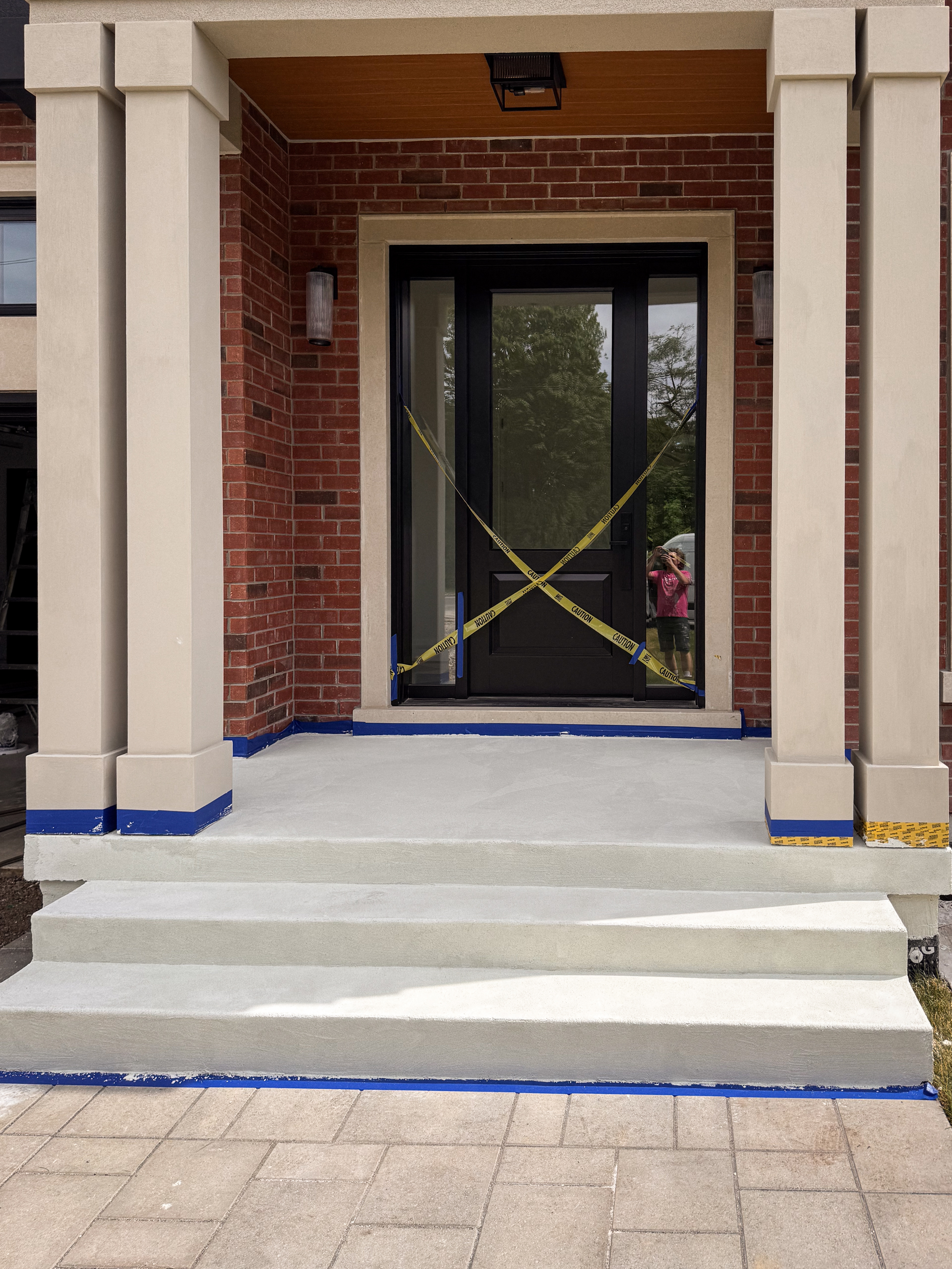 fine-grain-white-microcement-finish-trowel-application A close-up of a smooth, fine-grain white exterior microcement being meticulously troweled onto a front porch surface.