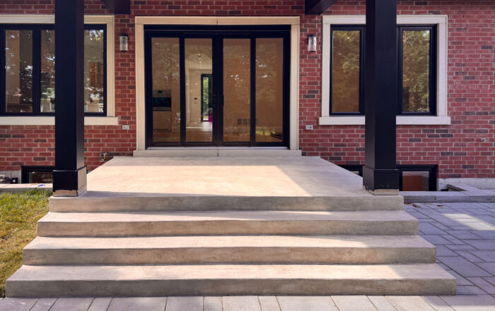 A modern front porch and back deck in Toronto finished in a smooth, seamless, soft warm white exterior microcement.