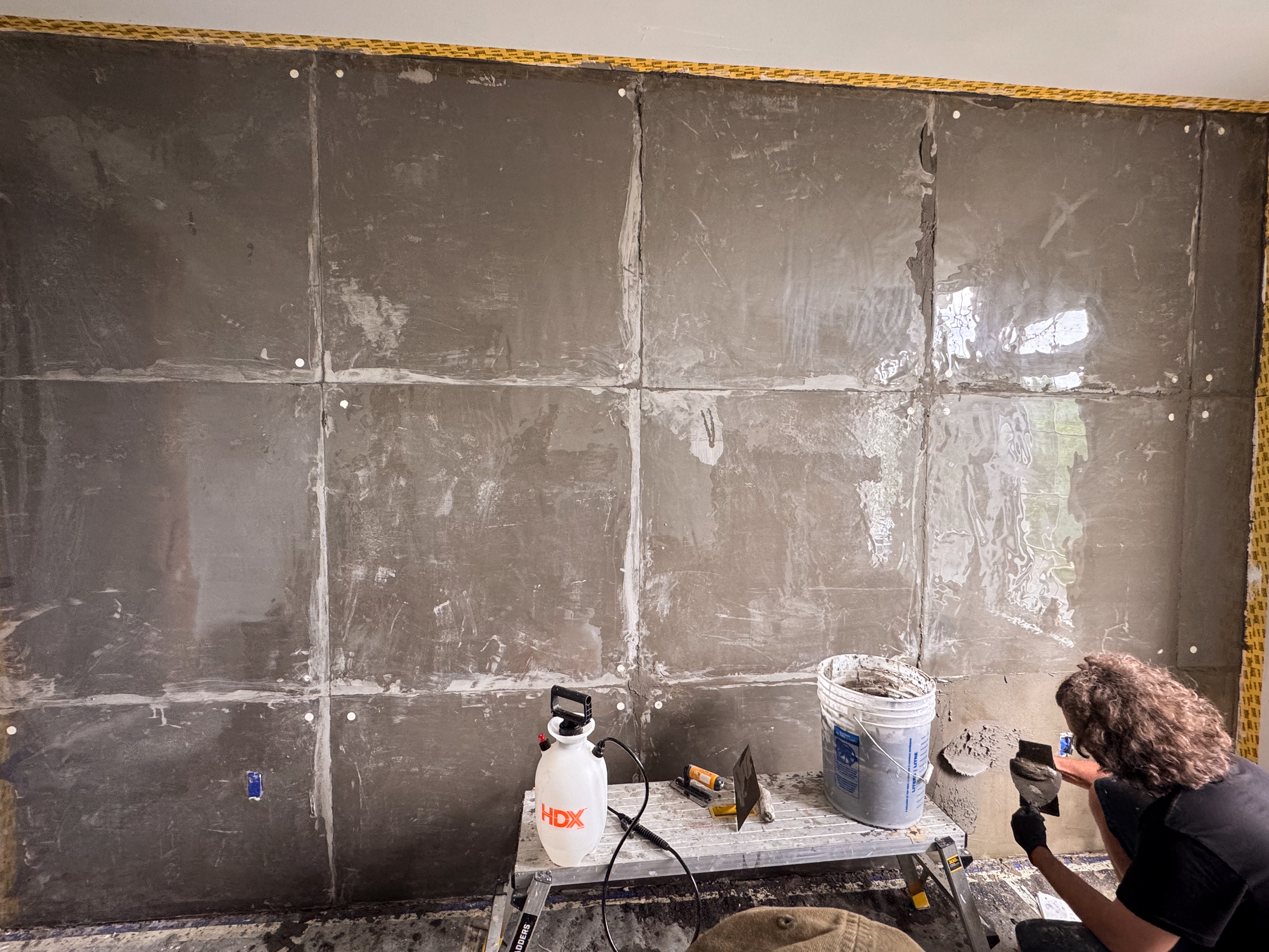 microcement-concrete-texture-wall-panel-detailing Custom concrete texture wall detailing using architectural vinyl sheet over fresh microcement plaster.
