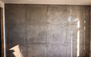 Custom concrete texture wall detailing using architectural vinyl sheet over fresh microcement plaster.