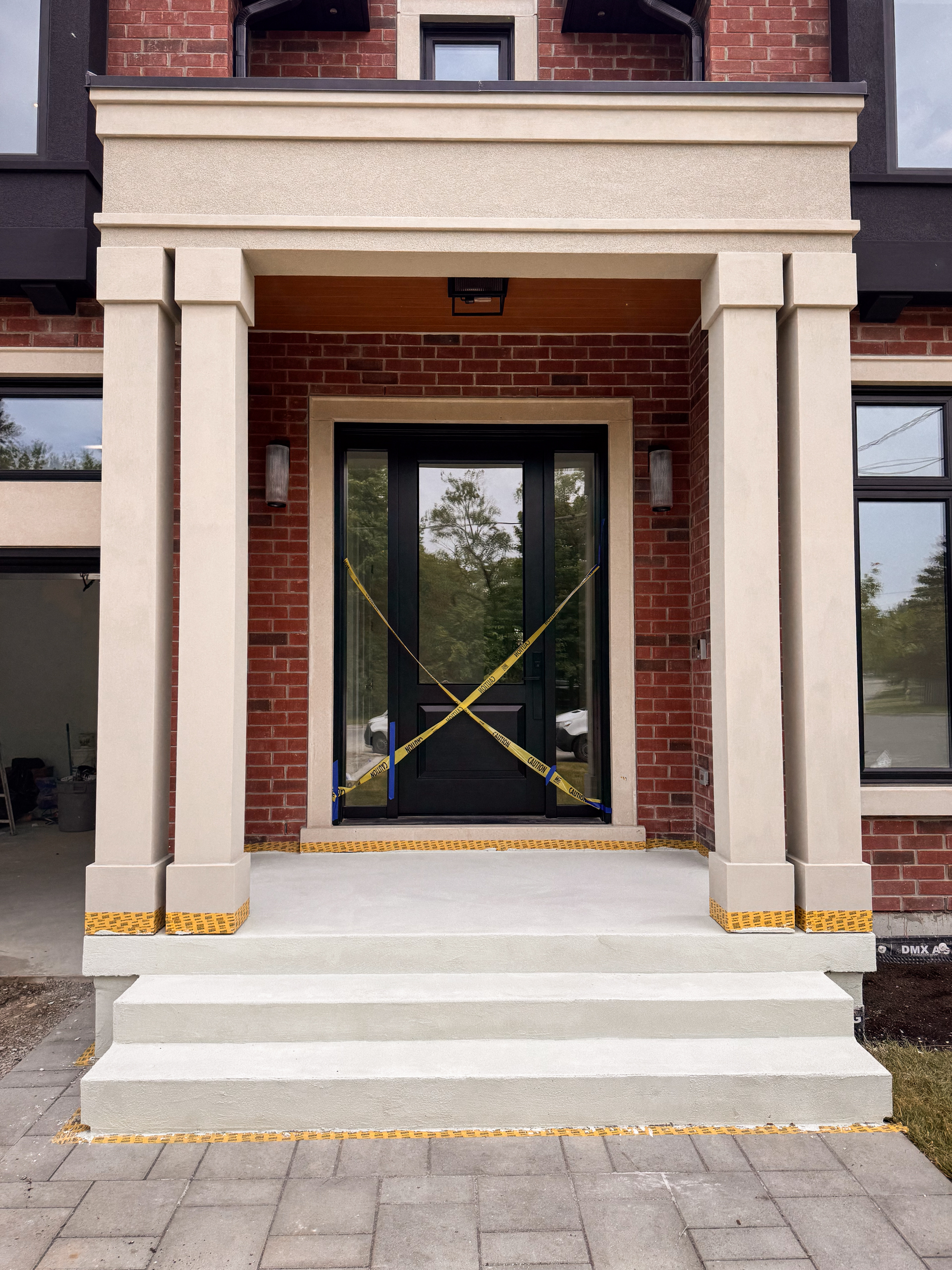 microcement-base-coat-fiberglass-mesh-installation Troweling a polymer-modified base coat and embedding a reinforcing fiberglass mesh over a concrete porch.