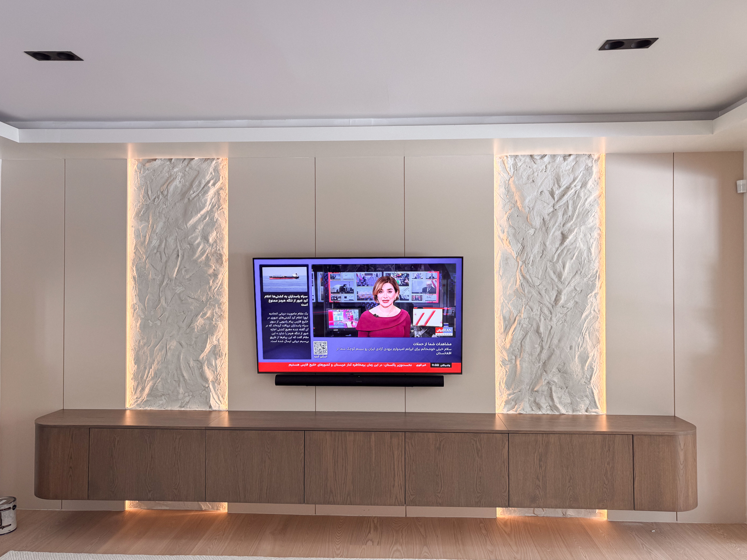 Custom dual TV accent rock effect wall toronto installation in warm off-white matching surrounding media panels.