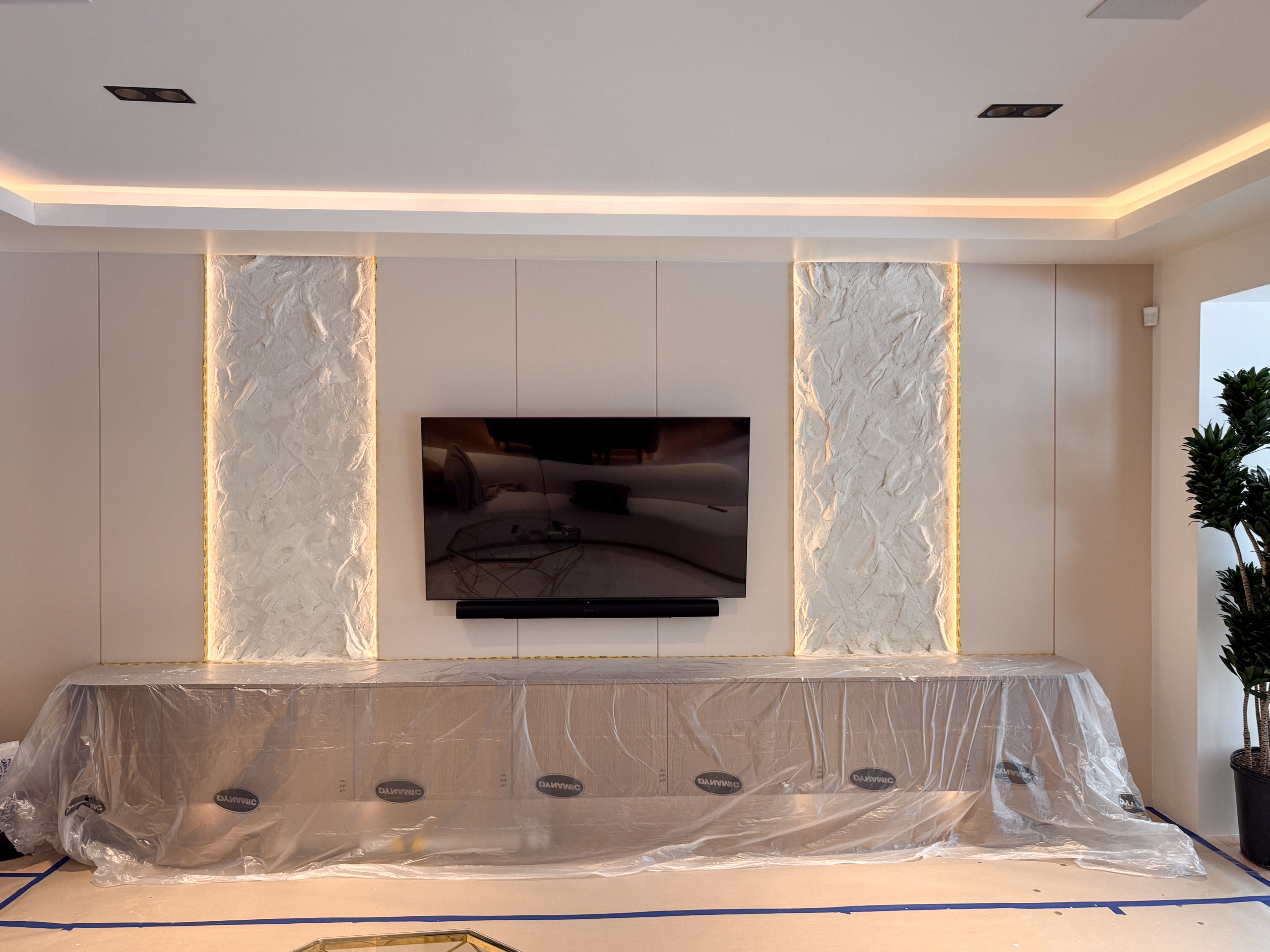 Custom dual TV accent rock effect wall toronto installation in warm off-white matching surrounding media panels.