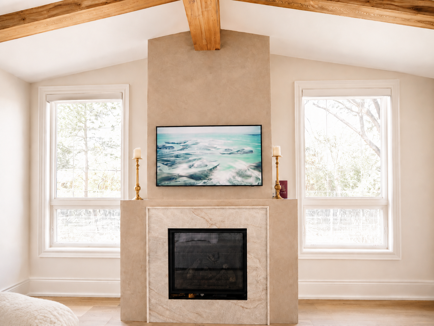 Taupe Venetian plaster on fireplace with creamy stone surround and exposed wood beams in a luxury Kleinburg ensuite