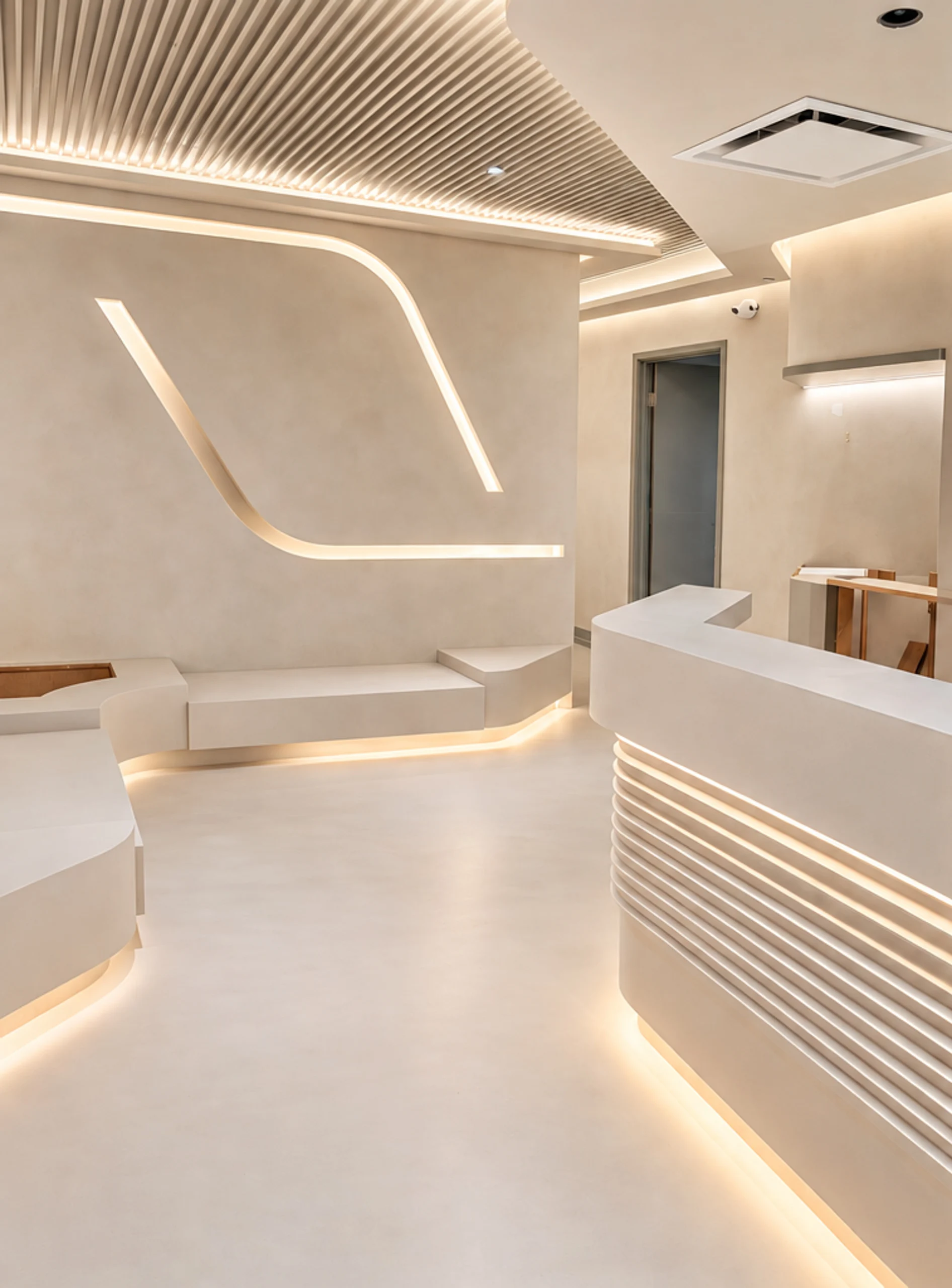 Microcement floors, bench, planters and reception desk with limewashed walls in a modern wellness center