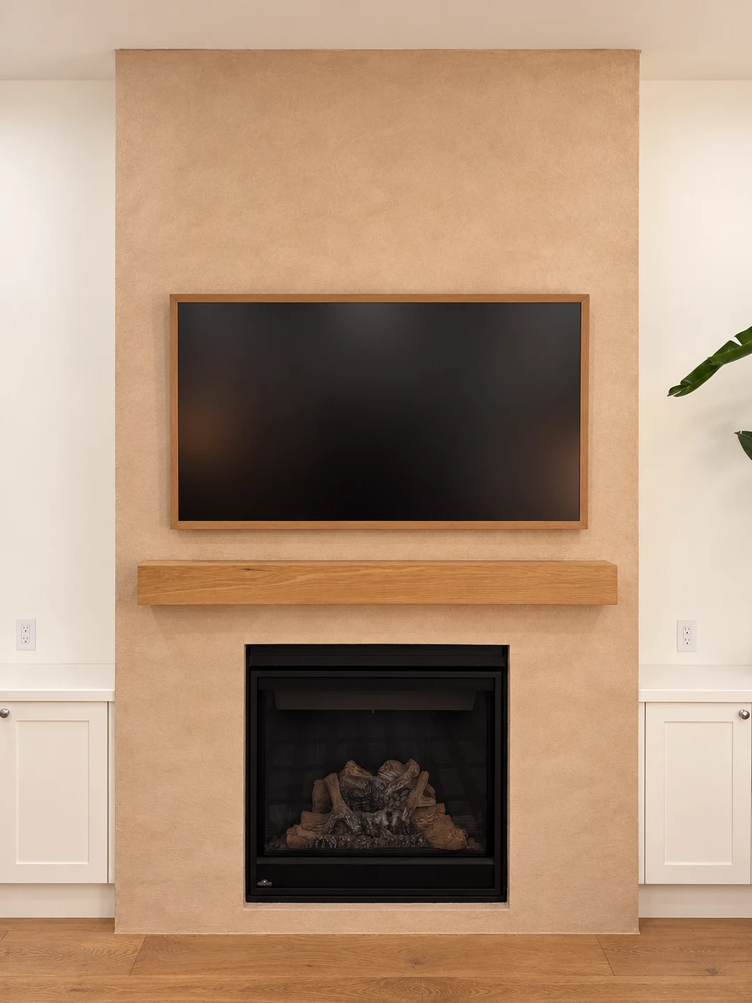 Front view of a monolithic taupe microcement fireplace surround in a High Park home.