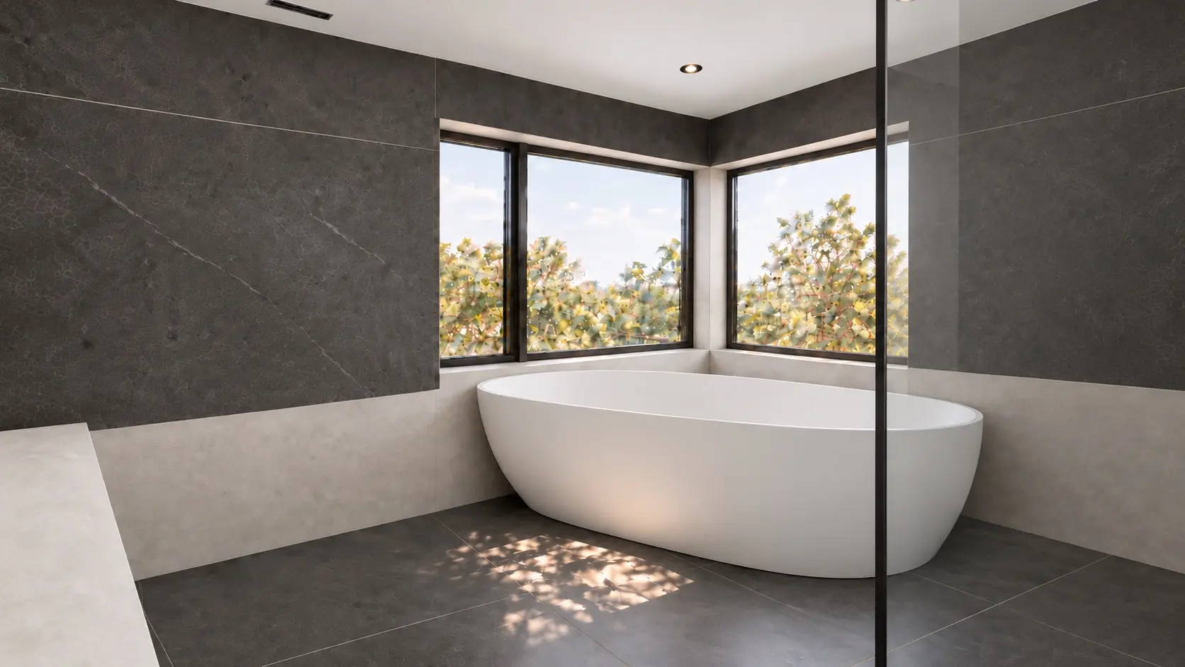 Freestanding tub beside charcoal shower walls and light greige microcement surfaces in a North York bathroom.